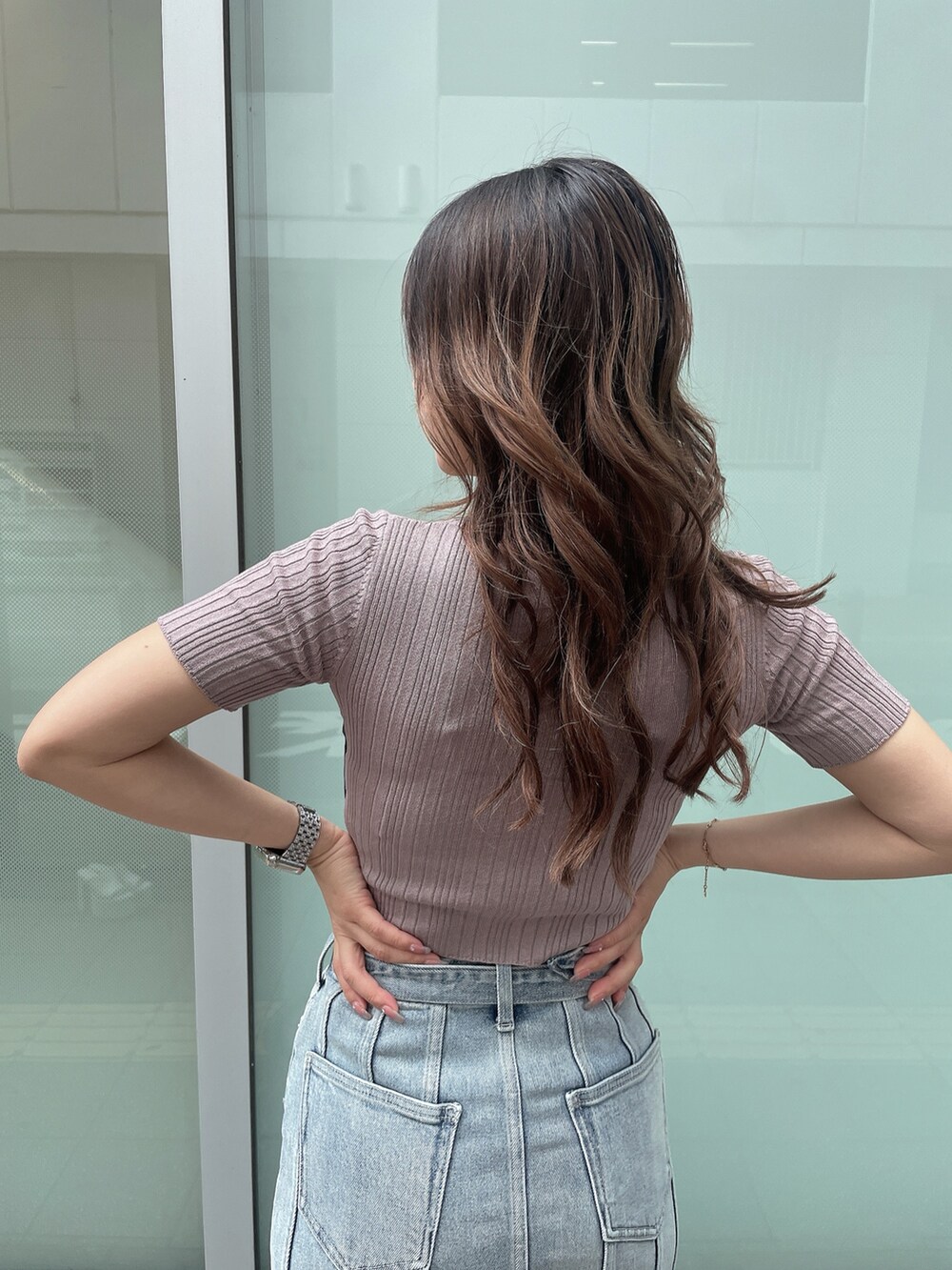 ピンク系のニット/セーター、ブルー系のデニムスカート、ホワイト系のサンダルを着用したレディースの夏コーディネートの5枚目の写真