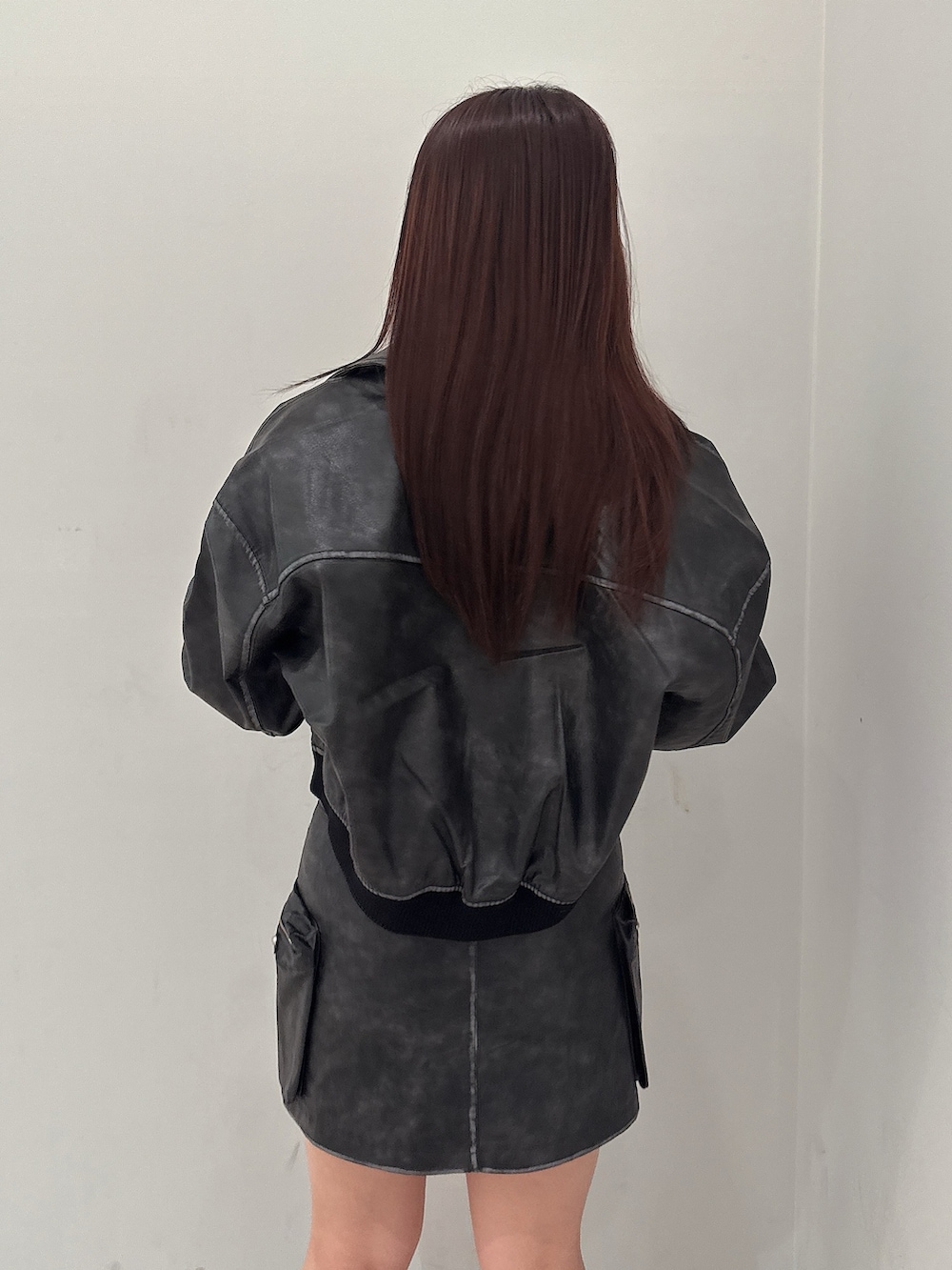 ブラック系のブーツ、ホワイト系のニット/セーター、ブラック系のスカートを着用したレディースの秋コーディネートの6枚目の写真