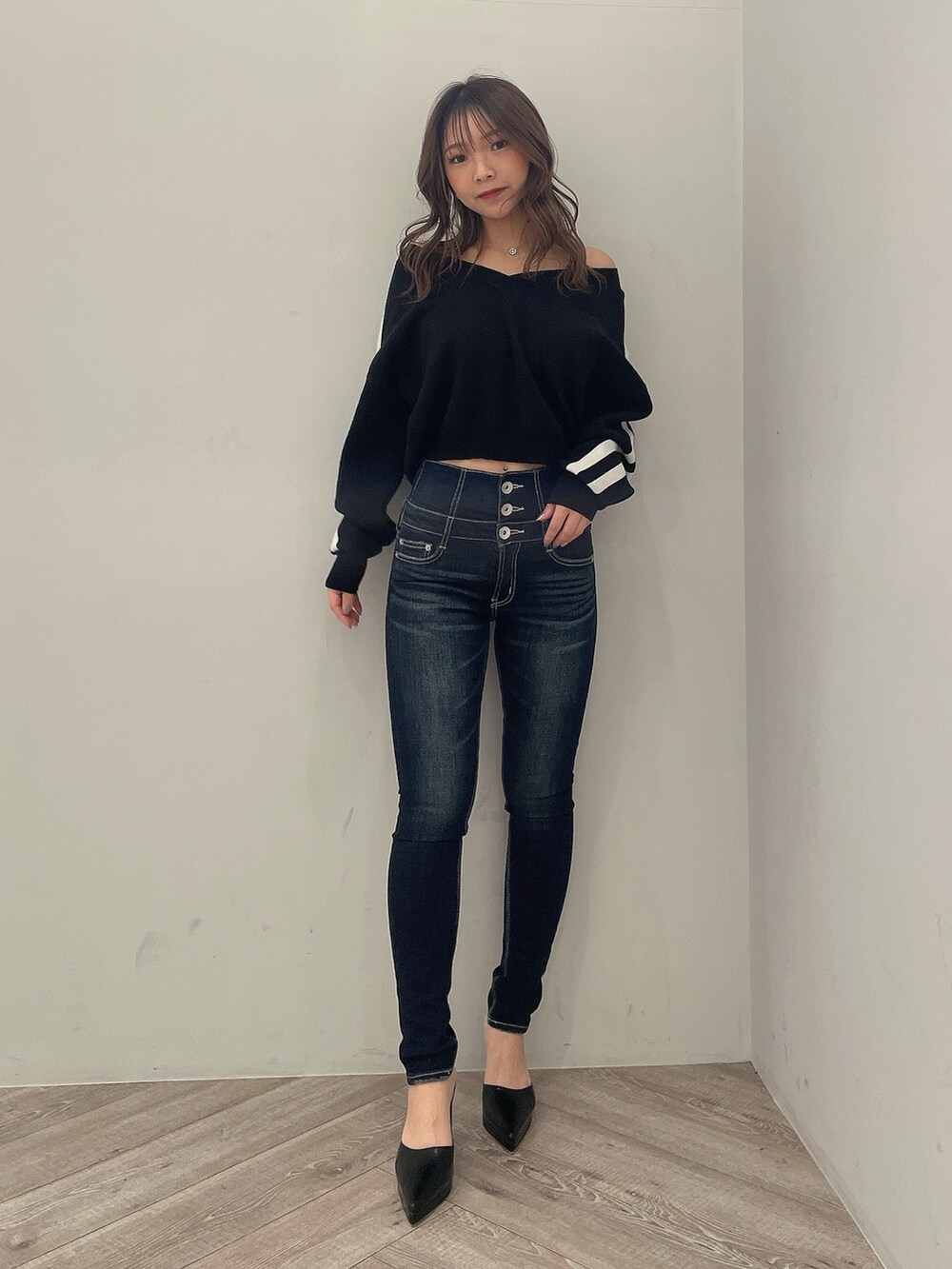 ブラック系のニット/セーター、ブルー系のデニムパンツ、ブラック系のパンプスを着用したレディースの冬コーディネートの2枚目の写真
