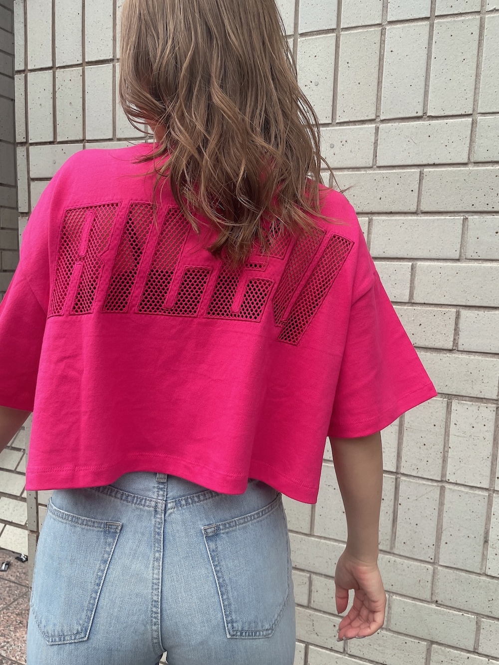 ブルー系のデニムパンツ、ホワイト系のサンダル、ピンク系のTシャツ/カットソーを着用したレディースの夏コーディネートの7枚目の写真