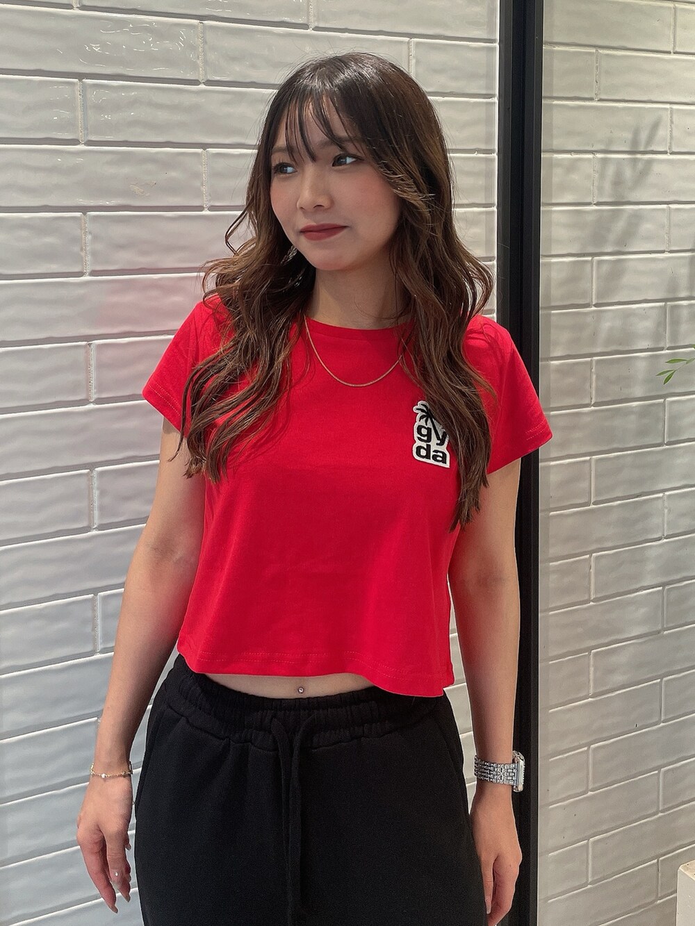 レッド系のTシャツ/カットソー、ブラック系のスウェットパンツ、ホワイト系のスニーカーを着用したレディースの夏コーディネートの4枚目の写真