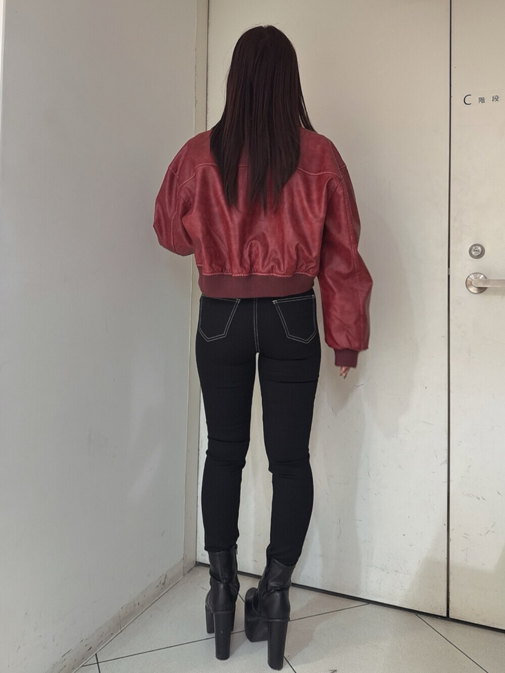 ブラック系のデニムパンツ、ブラック系のブーツ、ブラック系のニット/セーターを着用したレディースの秋コーディネートの3枚目の写真