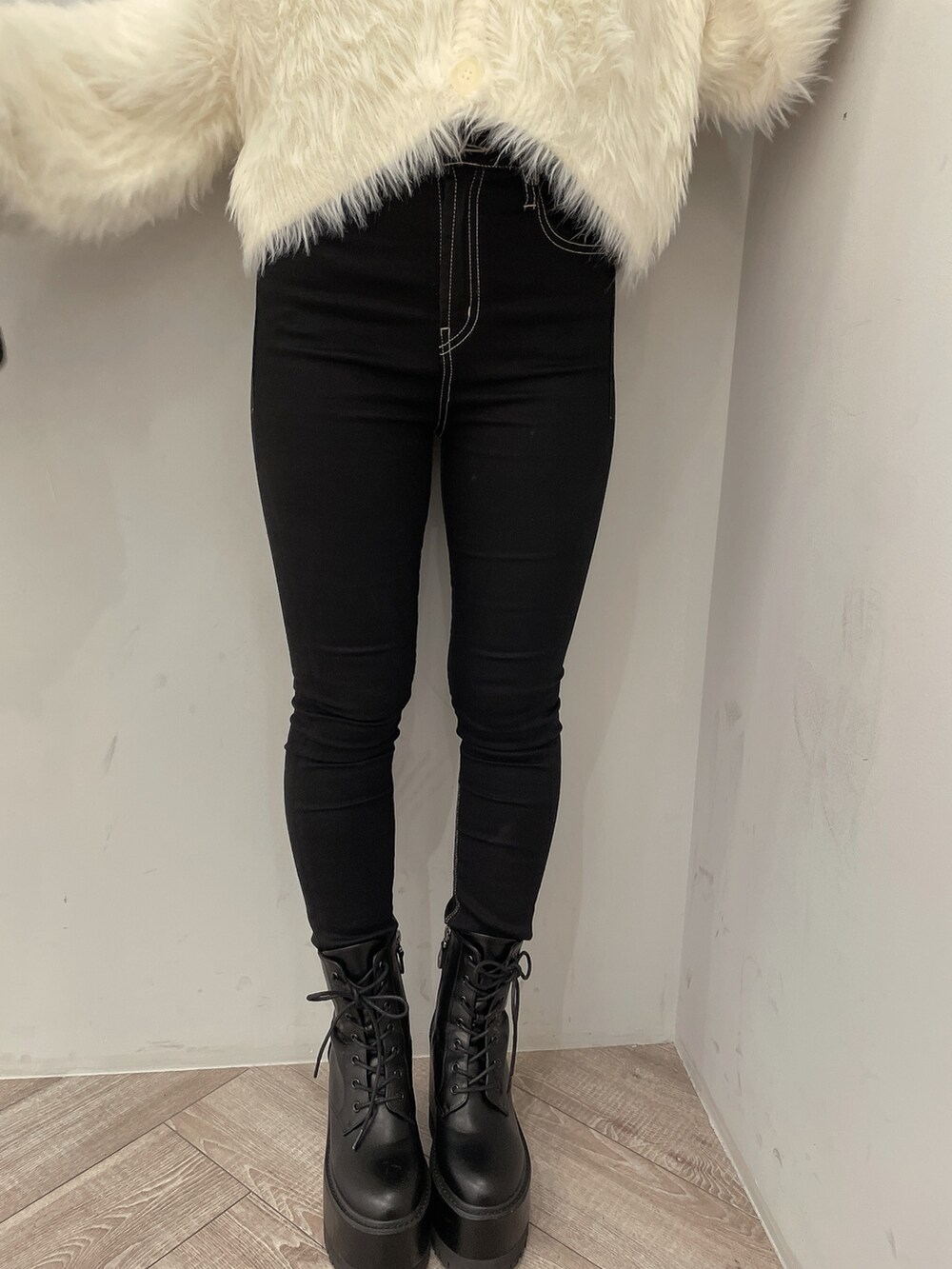 ブラック系のデニムパンツ、ブラック系のブーツ、ホワイト系のニット/セーターを着用したレディースの秋コーディネートの9枚目の写真