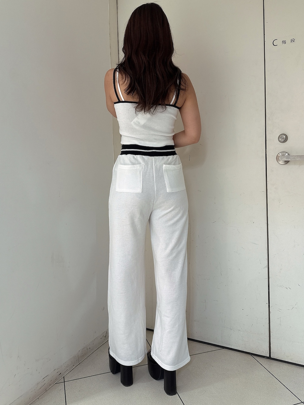 ブラック系のサンダル、ホワイト系のスウェットパンツ、ホワイト系のキャミソールを着用したレディースの夏コーディネートの3枚目の写真