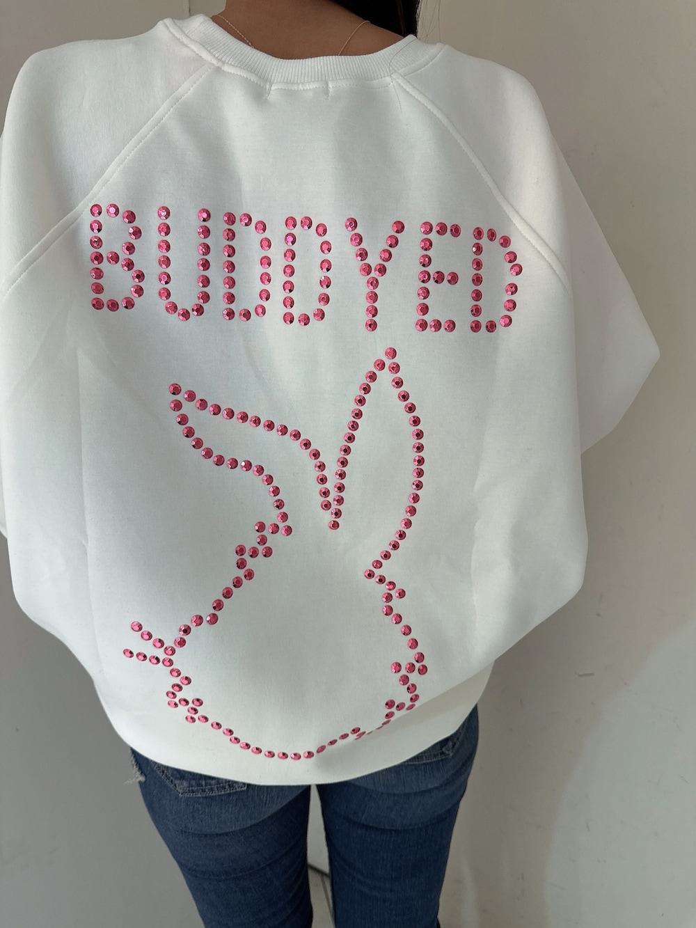 ブルー系のデニムパンツ、ブラック系のブーツ、ホワイト系のスウェットを着用したレディースの冬コーディネートの7枚目の写真