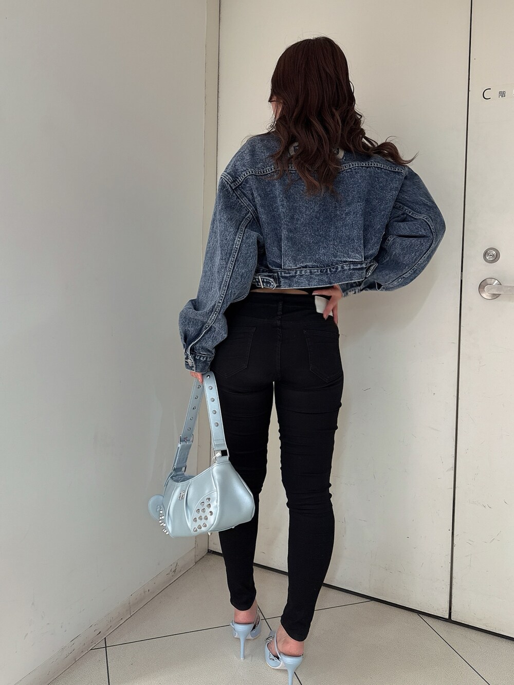 ブラック系のTシャツ/カットソー、ブルー系のデニムジャケット、ブラック系のデニムパンツを着用したレディースの春コーディネートの3枚目の写真