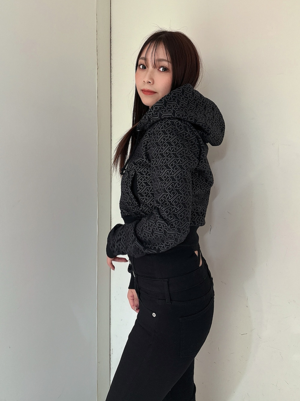 ブラック系のデニムパンツ、ブラック系のパーカー、ブラック系のブーツを着用したレディースの冬コーディネートの5枚目の写真