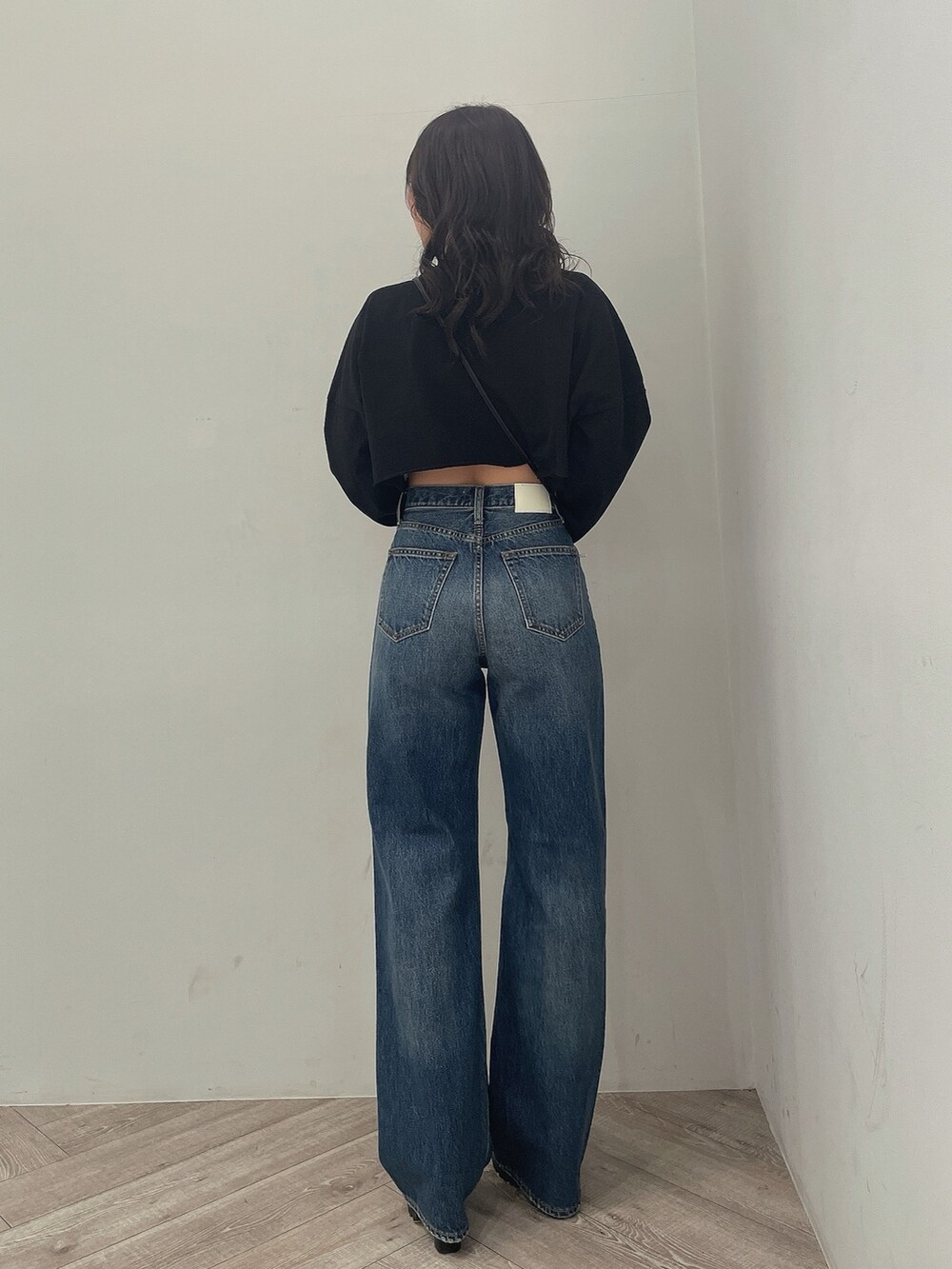 ブラック系のTシャツ/カットソー、ブルー系のデニムパンツ、ブラック系のブーツを着用したレディースの春コーディネートの3枚目の写真