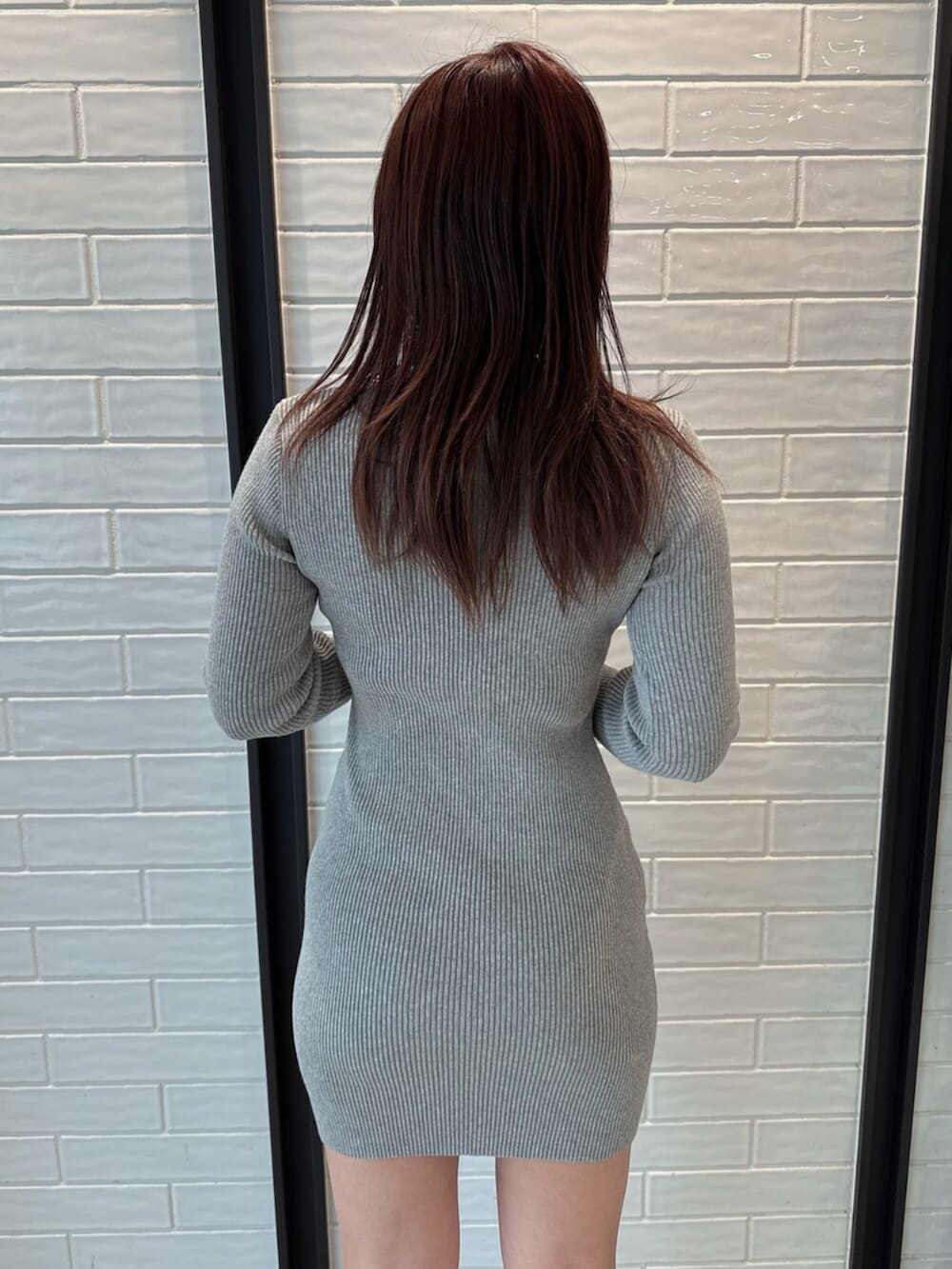 ブラック系のブーツ、グレー系のワンピースを着用したレディースの冬コーディネートの9枚目の写真