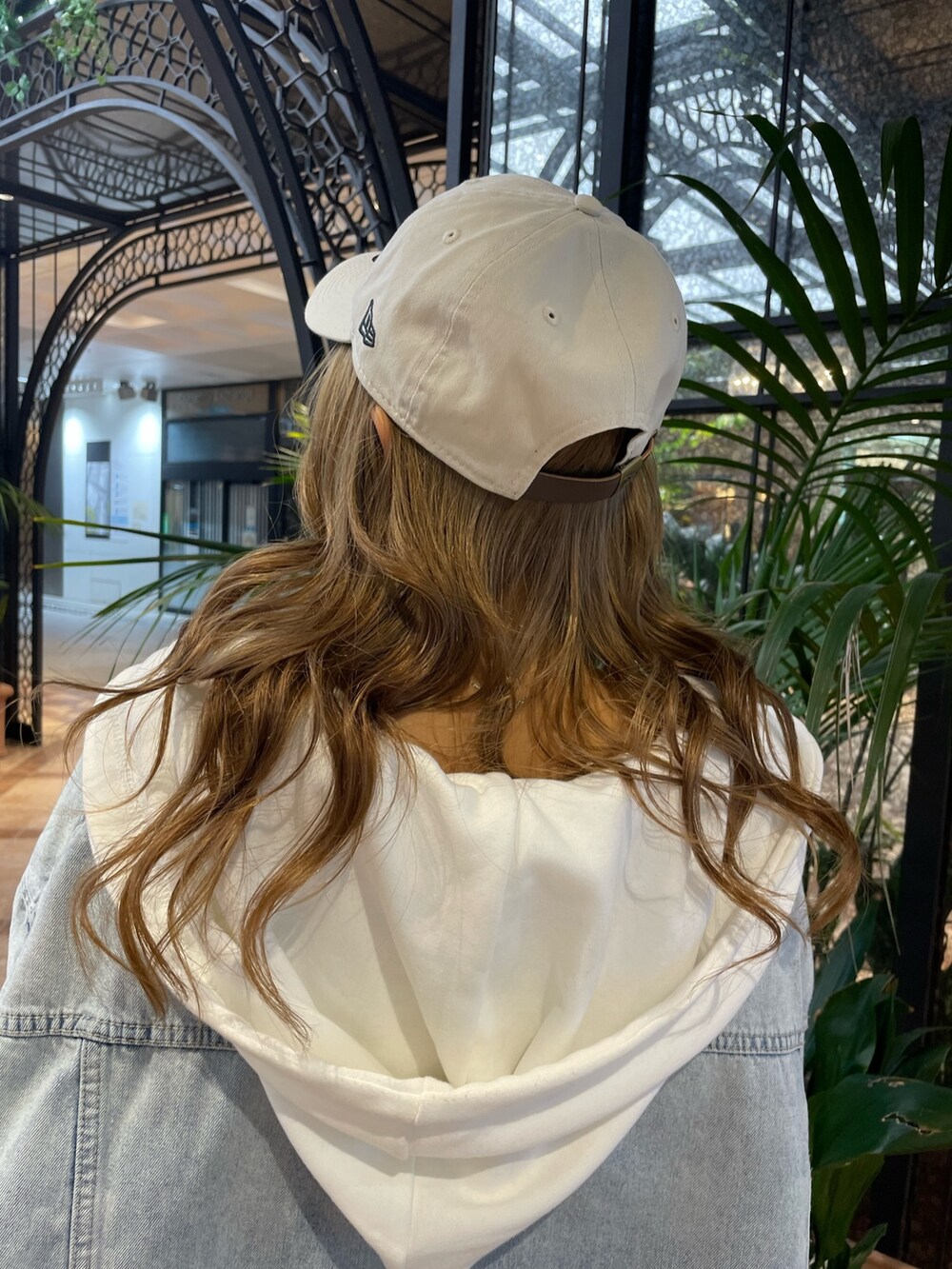 ホワイト系のキャミソール、ホワイト系のパーカー、ブルー系のデニムジャケットを着用したレディースの春コーディネートの8枚目の写真