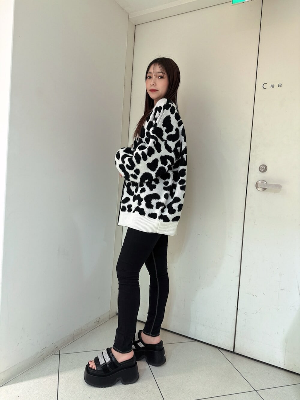 ブラック系のデニムパンツ、ブラック系のサンダル、ホワイト系のカーディガン/ボレロを着用したレディースの春コーディネートの2枚目の写真