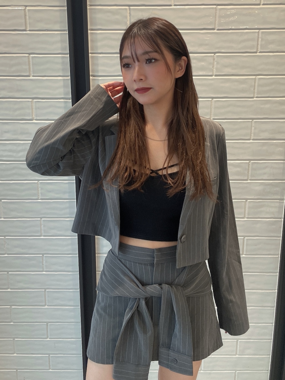 グレー系のスカート、ブラック系のブーツ、グレー系のテーラードジャケットを着用したレディースの夏コーディネートの4枚目の写真