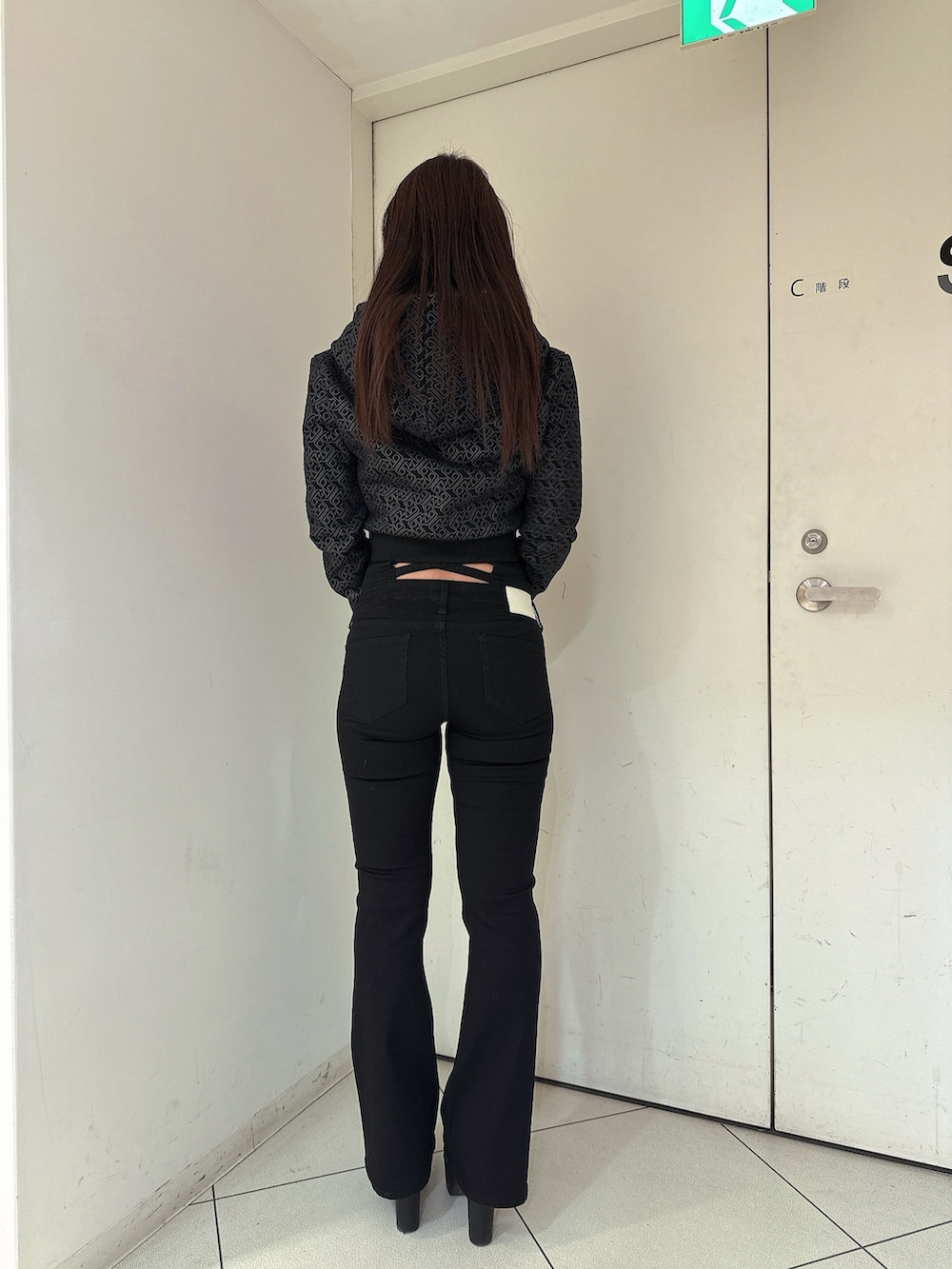 ブラック系のデニムパンツ、ブラック系のパーカー、ブラック系のブーツを着用したレディースの冬コーディネートの3枚目の写真