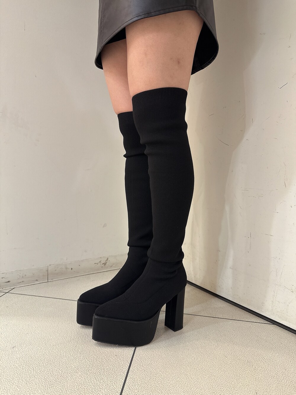 ブラック系のブーツ、ブラック系のスカート、ブラック系のチュニックを着用したレディースの秋コーディネートの9枚目の写真