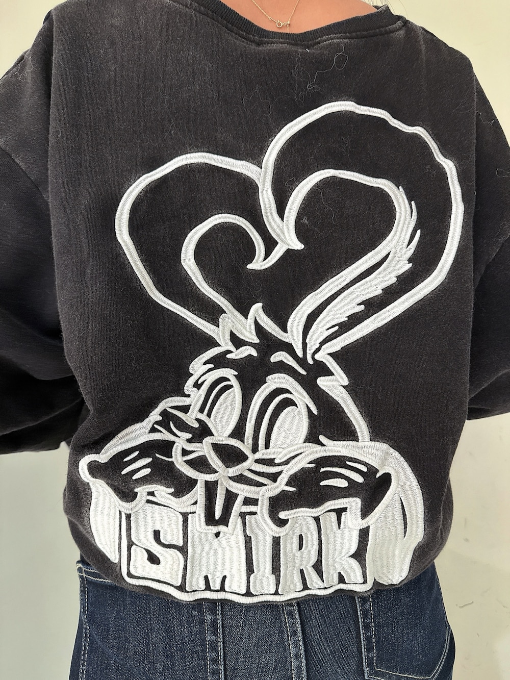 ブルー系のデニムパンツ、ブラック系のスウェット、ブラック系のブーツを着用したレディースの冬コーディネートの7枚目の写真