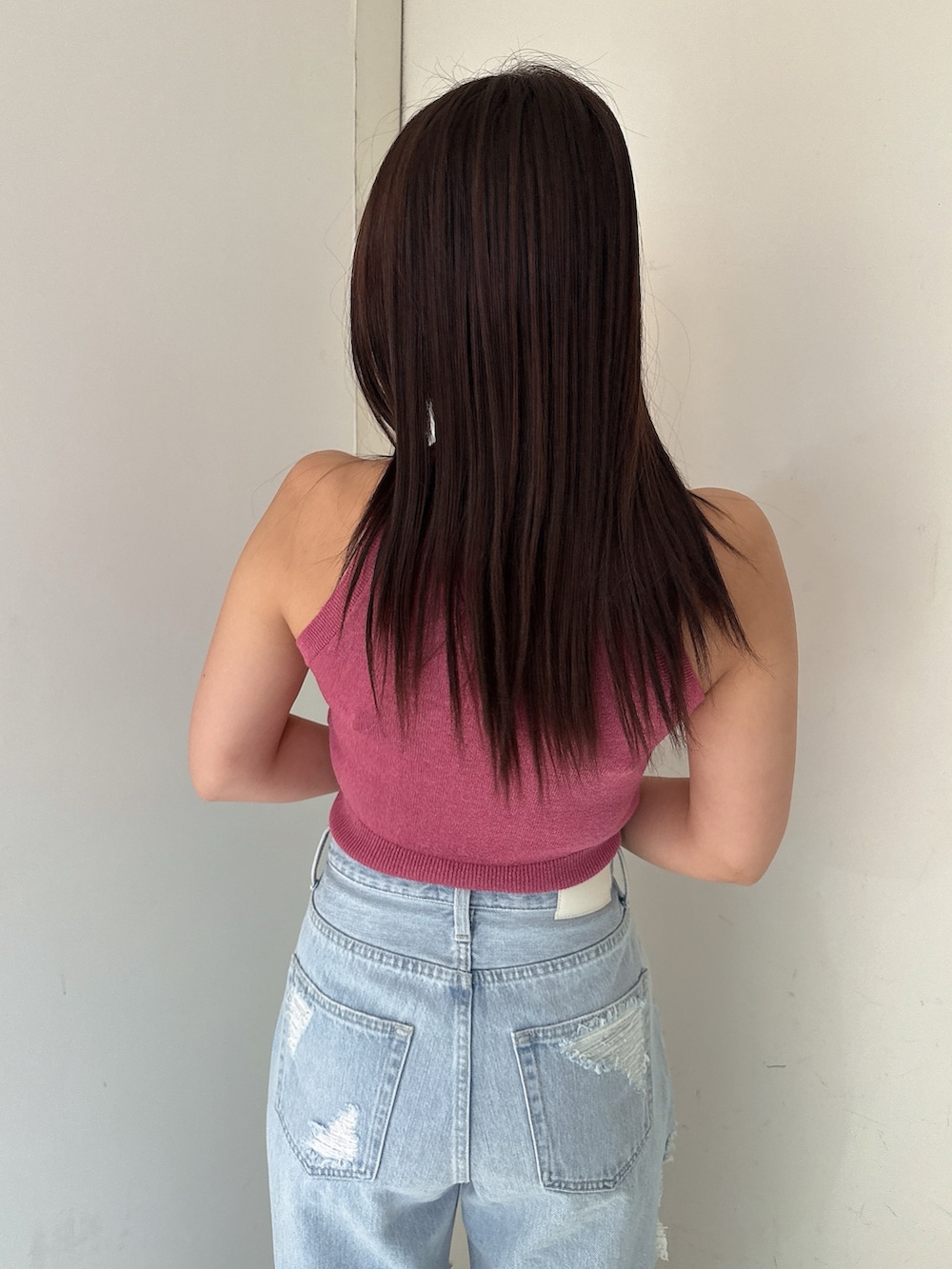 ブルー系のデニムパンツ、ホワイト系のサンダル、ピンク系のニット/セーターを着用したレディースの夏コーディネートの6枚目の写真