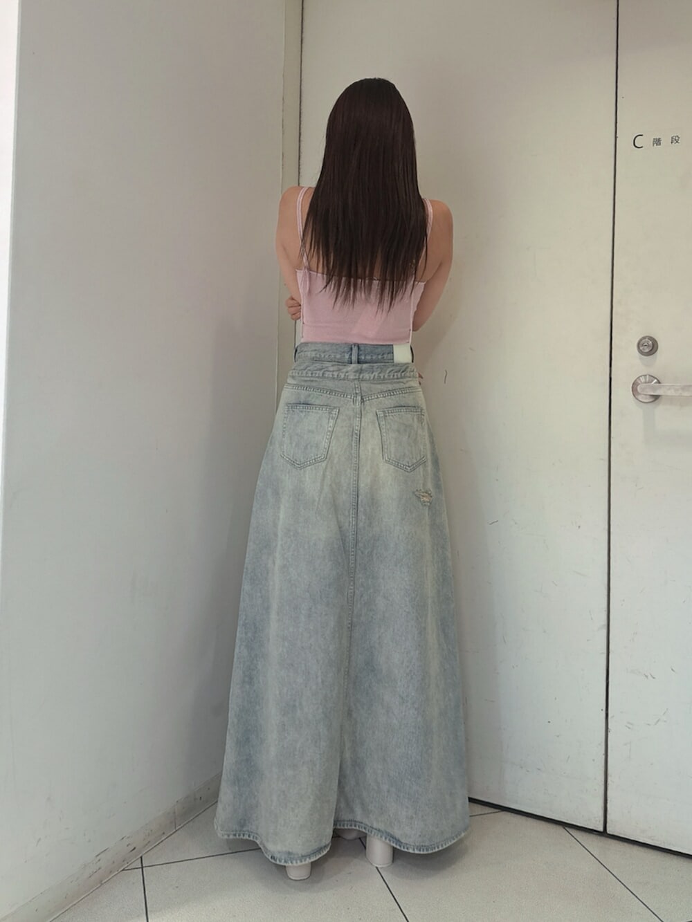 ホワイト系のサンダル、ブルー系のデニムスカート、ピンク系のキャミソールを着用したレディースの夏コーディネートの3枚目の写真
