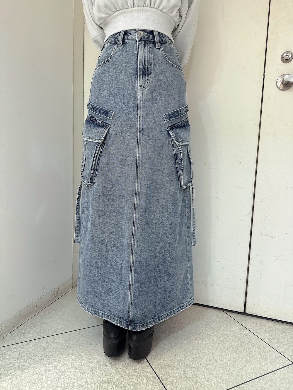 ブルー系のデニムスカート、ホワイト系のTシャツ/カットソー、ブラック系のブーツを着用したレディースの冬コーディネートの8枚目の写真