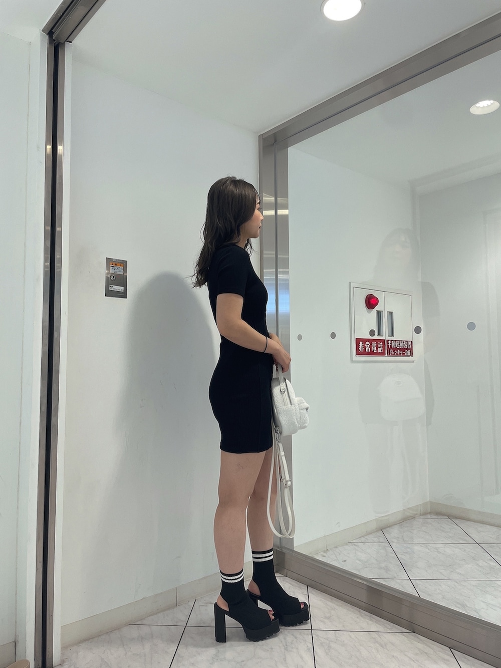 ブラック系のワンピース、ホワイト系のバックパック/リュック、その他のブーツを着用したレディースの夏コーディネートの2枚目の写真