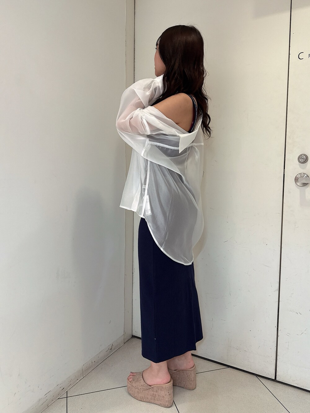 ブルー系のワンピース、ホワイト系のシャツ/ブラウス、ホワイト系のサンダルを着用したレディースの春コーディネートの2枚目の写真