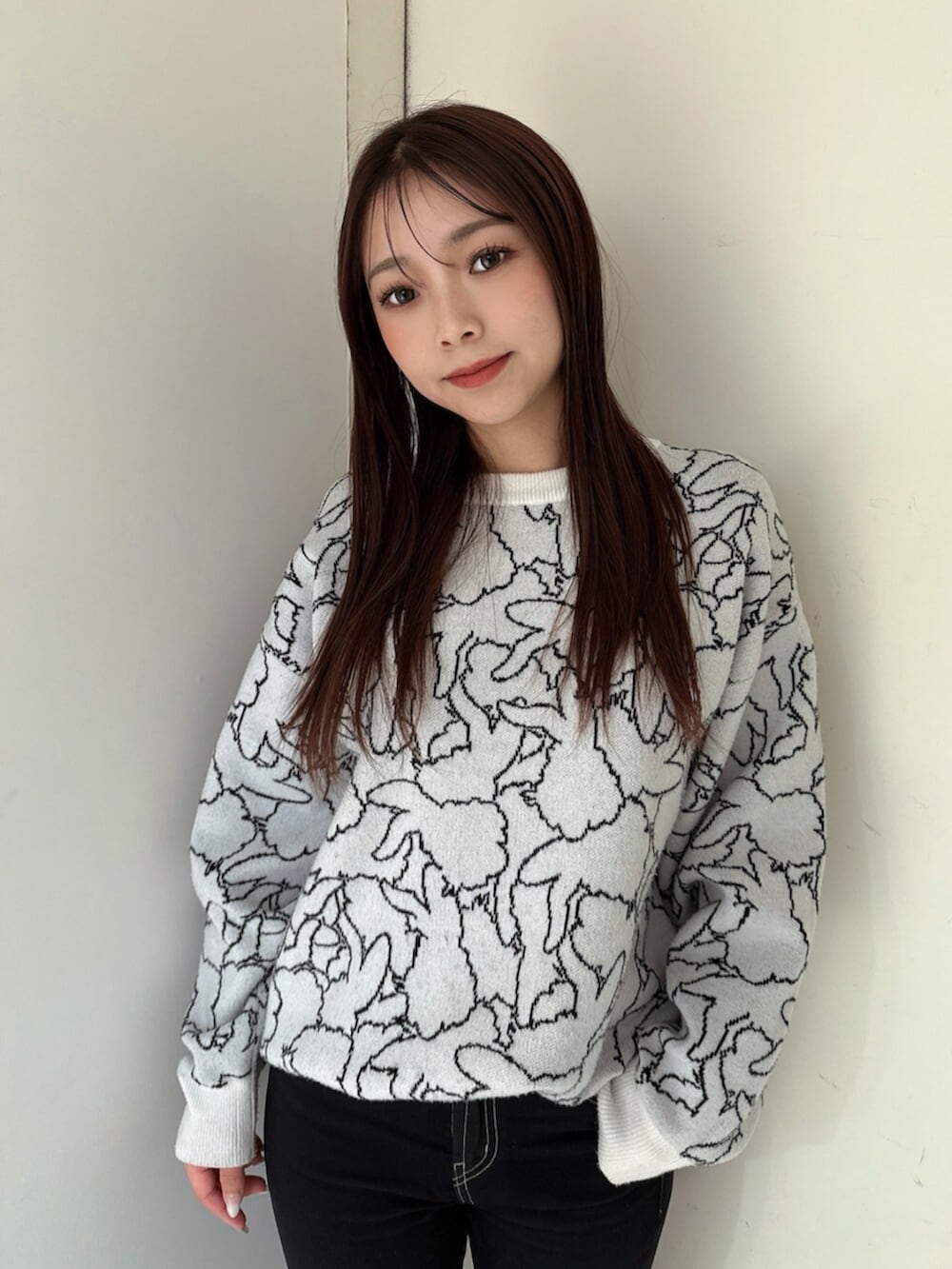 ブラック系のデニムパンツ、ブラック系のブーツ、ホワイト系のニット/セーターを着用したレディースの冬コーディネートの4枚目の写真