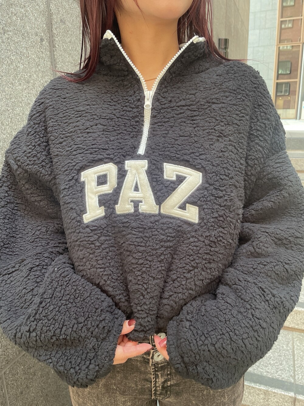 ブラック系のパーカー、ブラック系のデニムパンツ、ブラック系のブーツを着用したレディースの秋コーディネートの7枚目の写真