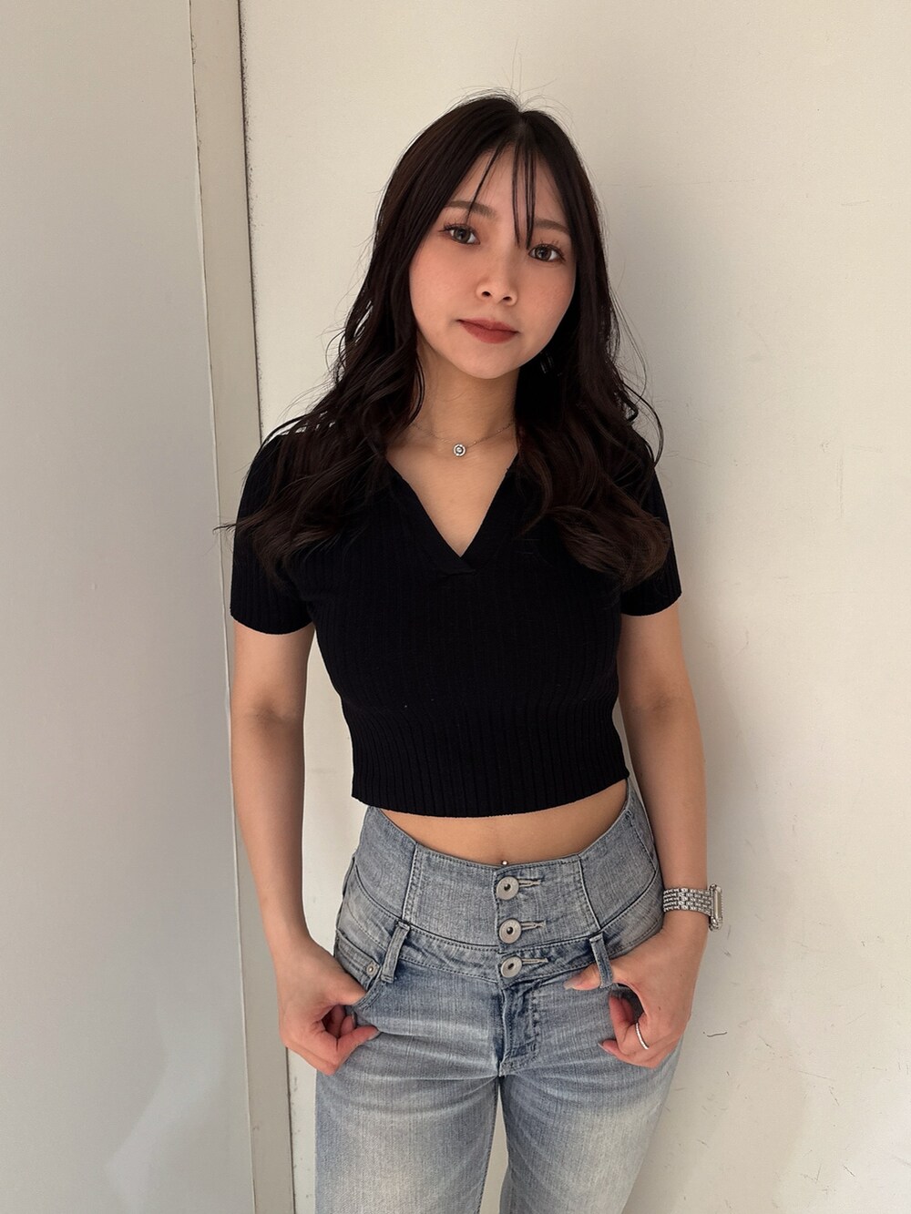 ブルー系のデニムパンツ、ブラック系のニット/セーター、ホワイト系のサンダルを着用したレディースの春コーディネートの4枚目の写真