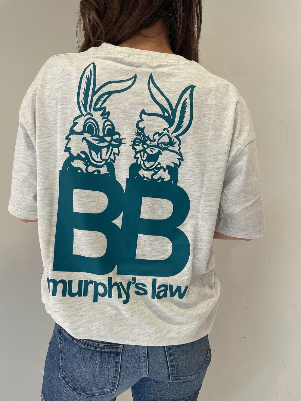 グレー系のTシャツ/カットソー、ブルー系のデニムパンツ、ホワイト系のサンダルを着用したレディースの夏コーディネートの6枚目の写真