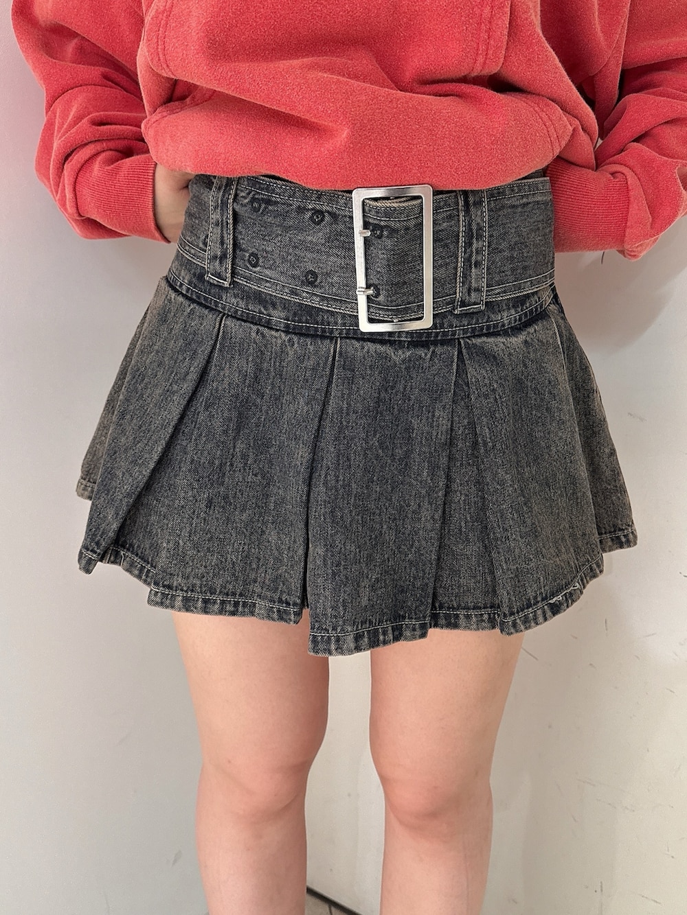 レッド系のパーカー、その他のデニムスカート、ブラック系のブーツを着用したレディースの秋コーディネートの8枚目の写真