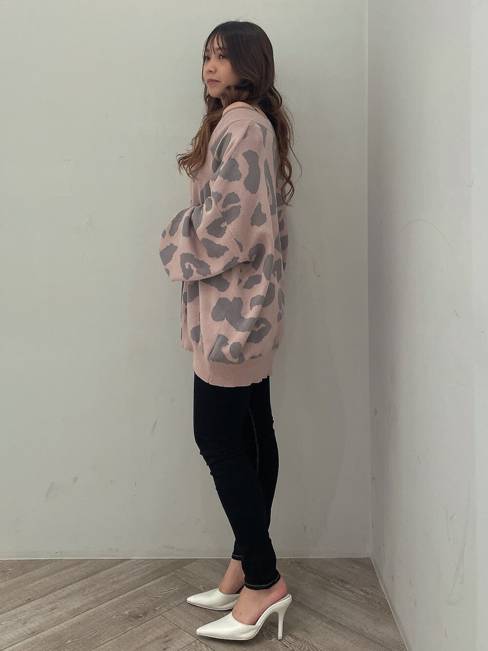 ピンク系のカーディガン/ボレロ、ブラック系のキャミソール、ブラック系のデニムパンツを着用したレディースの秋コーディネートの2枚目の写真