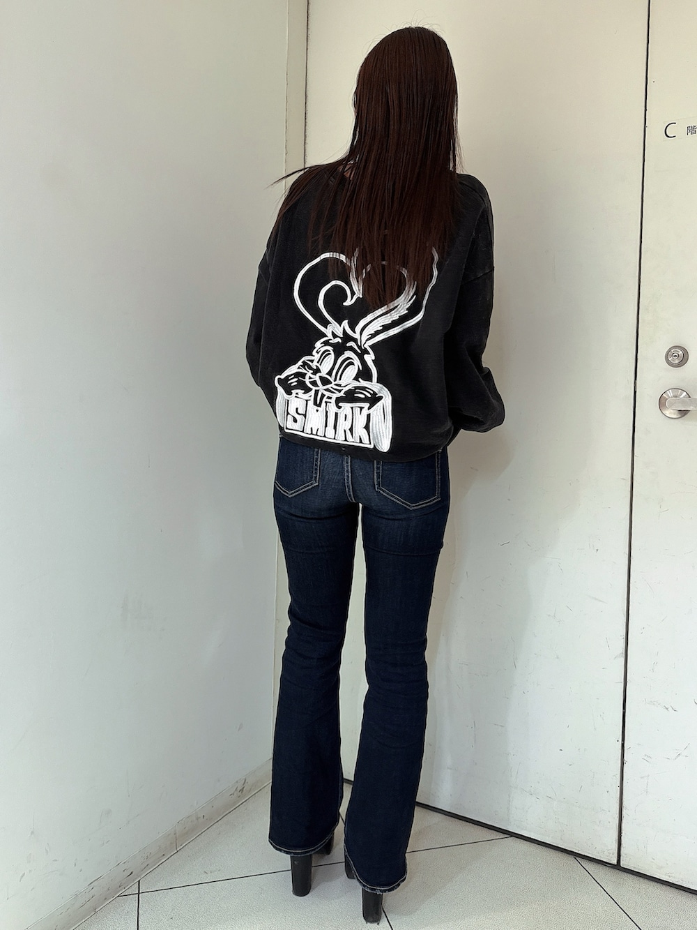 ブルー系のデニムパンツ、ブラック系のスウェット、ブラック系のブーツを着用したレディースの冬コーディネートの3枚目の写真