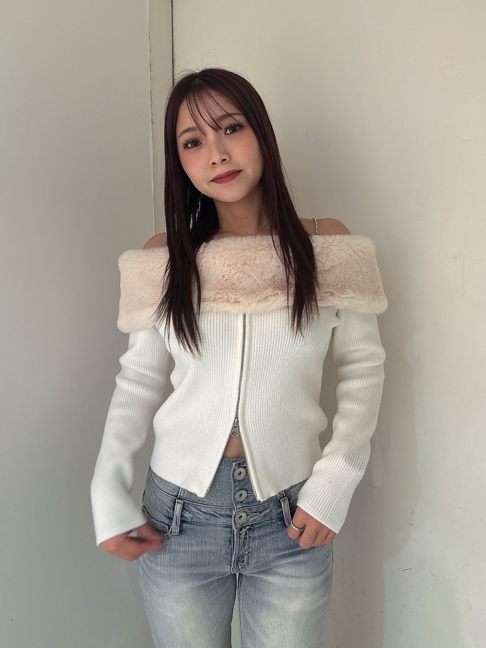 ホワイト系のニット/セーター、ブルー系のデニムパンツ、ブラック系のブーツを着用したレディースの秋コーディネートの4枚目の写真