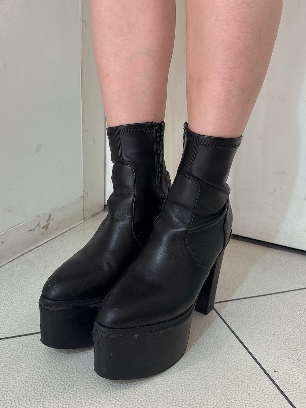 ブラック系のニット/セーター、ブラック系のデニムパンツ、ブラック系のブーツを着用したレディースの秋コーディネートの10枚目の写真