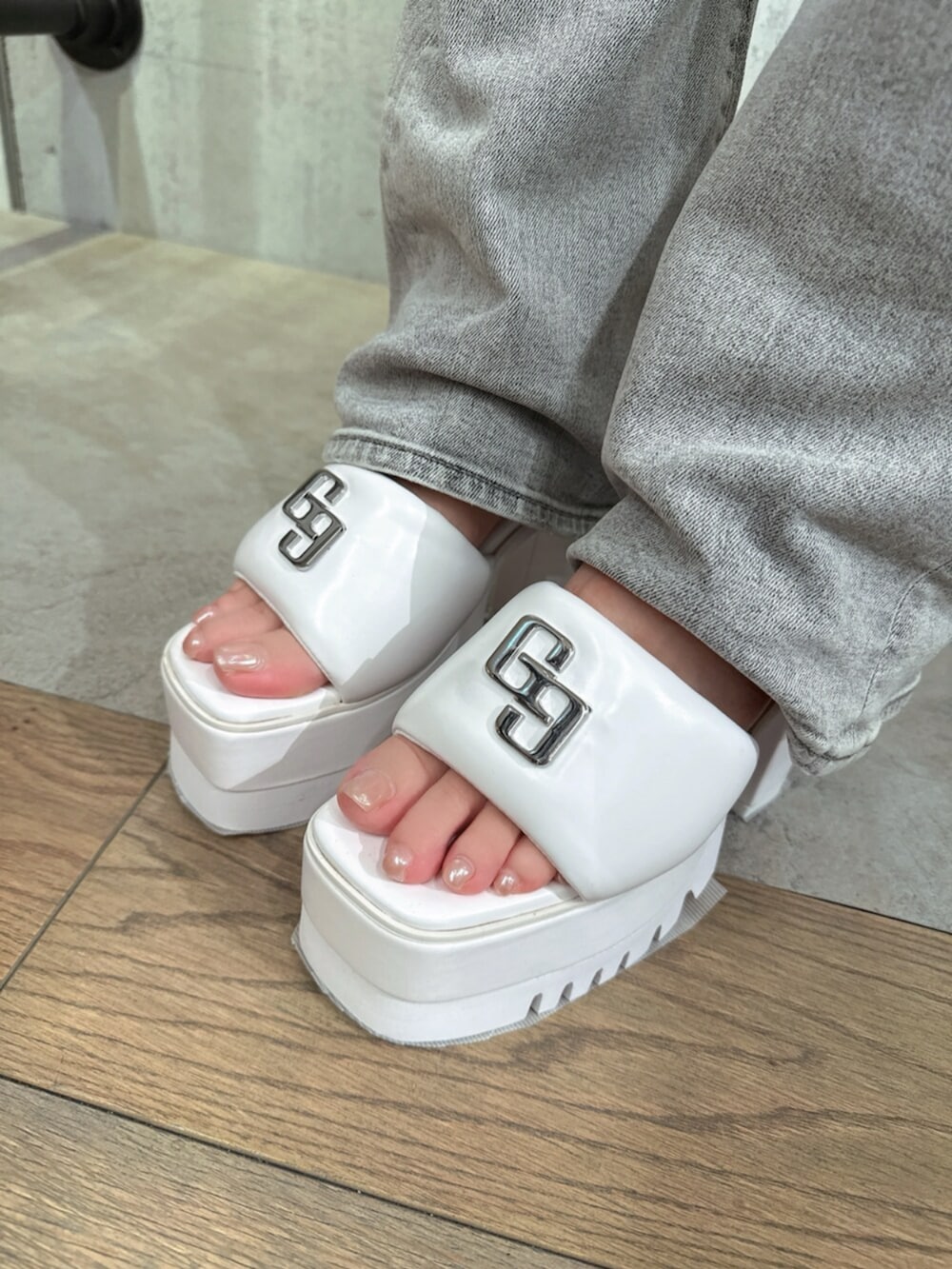 グレー系のデニムパンツ、ホワイト系のサンダル、ピンク系のTシャツ/カットソーを着用したレディースの夏コーディネートの10枚目の写真