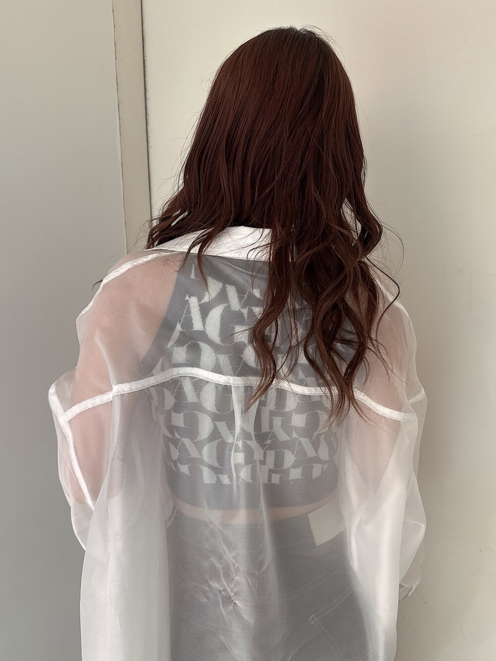 ブラック系のニット/セーター、ブラック系のデニムパンツ、ホワイト系のシャツ/ブラウスを着用したレディースの春コーディネートの6枚目の写真