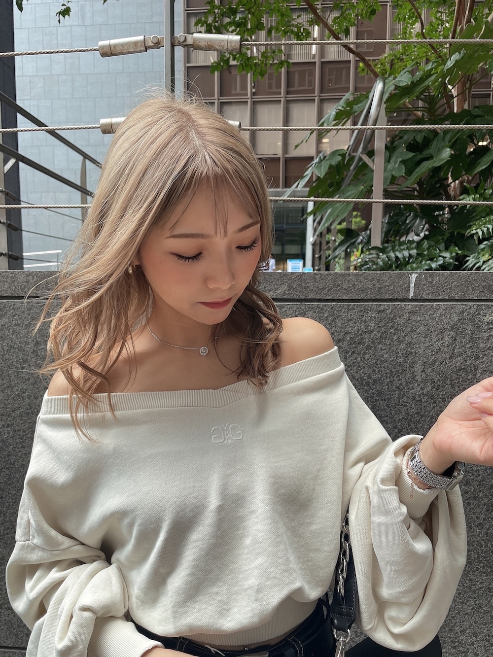 ブラック系のハンドバッグ、ホワイト系のスウェット、ホワイト系のチューブトップを着用したレディースの夏コーディネートの3枚目の写真