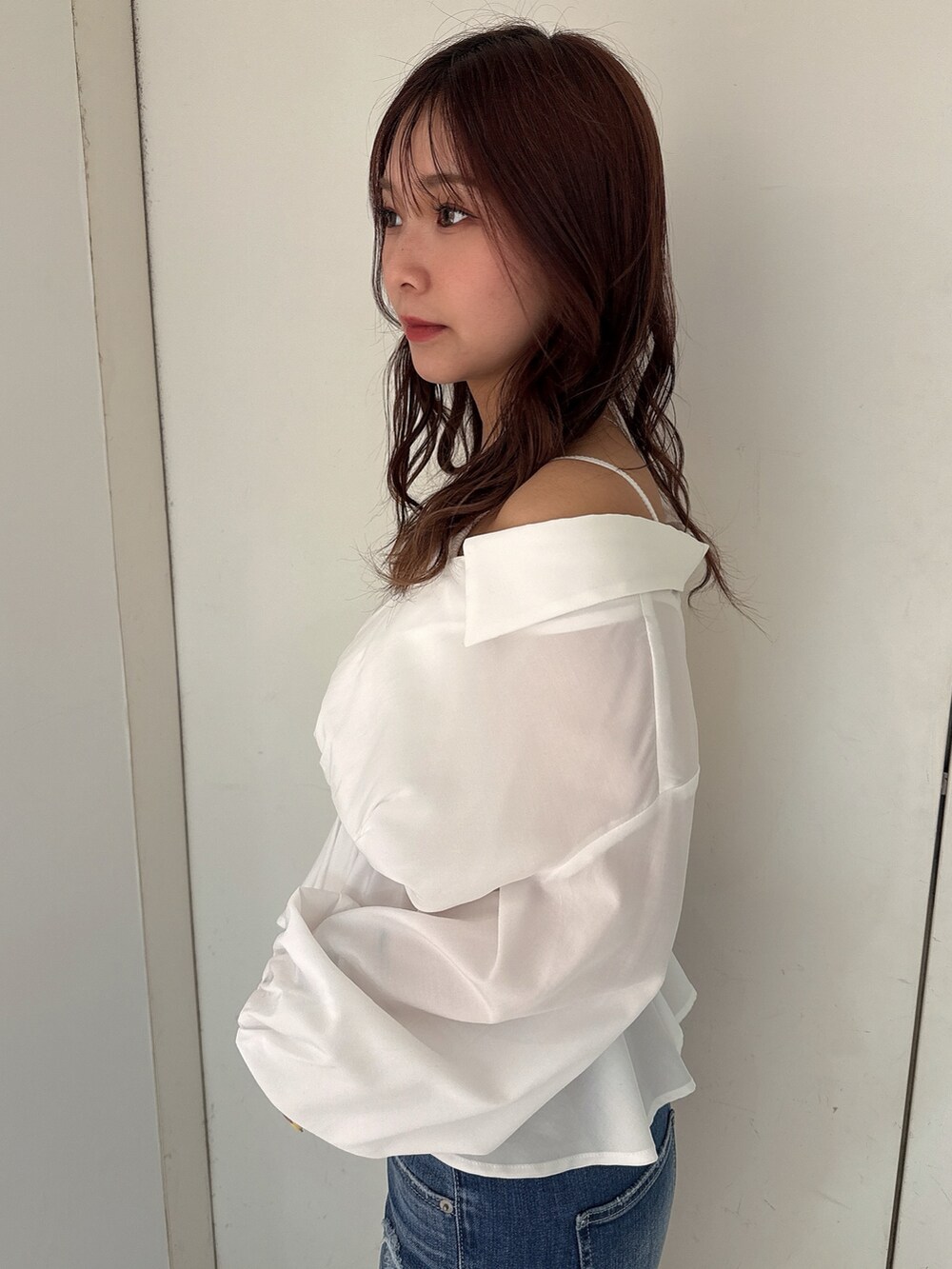 ブルー系のデニムパンツ、ホワイト系のパンプス、ホワイト系のシャツ/ブラウスを着用したレディースの冬コーディネートの5枚目の写真
