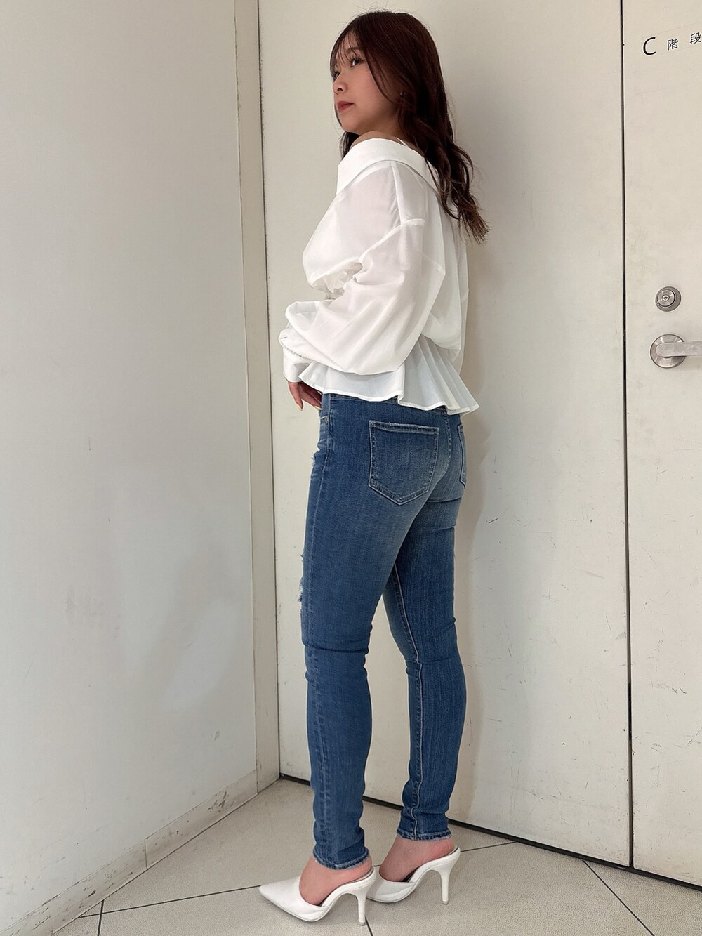 ブルー系のデニムパンツ、ホワイト系のパンプス、ホワイト系のシャツ/ブラウスを着用したレディースの冬コーディネートの2枚目の写真