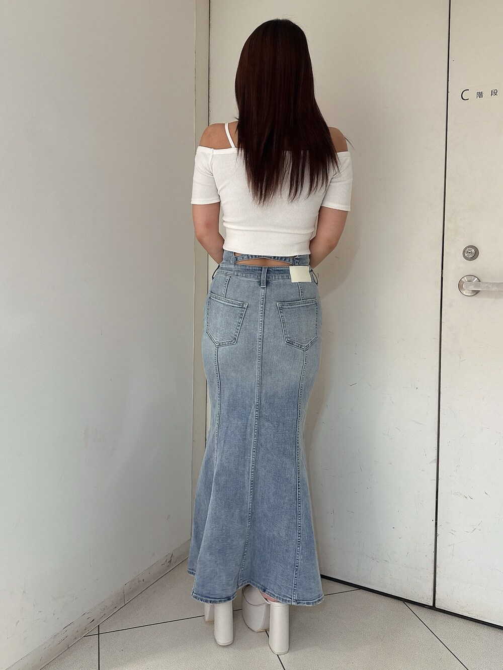 ホワイト系のTシャツ/カットソー、ブルー系のデニムスカート、ホワイト系のサンダルを着用したレディースの夏コーディネートの3枚目の写真