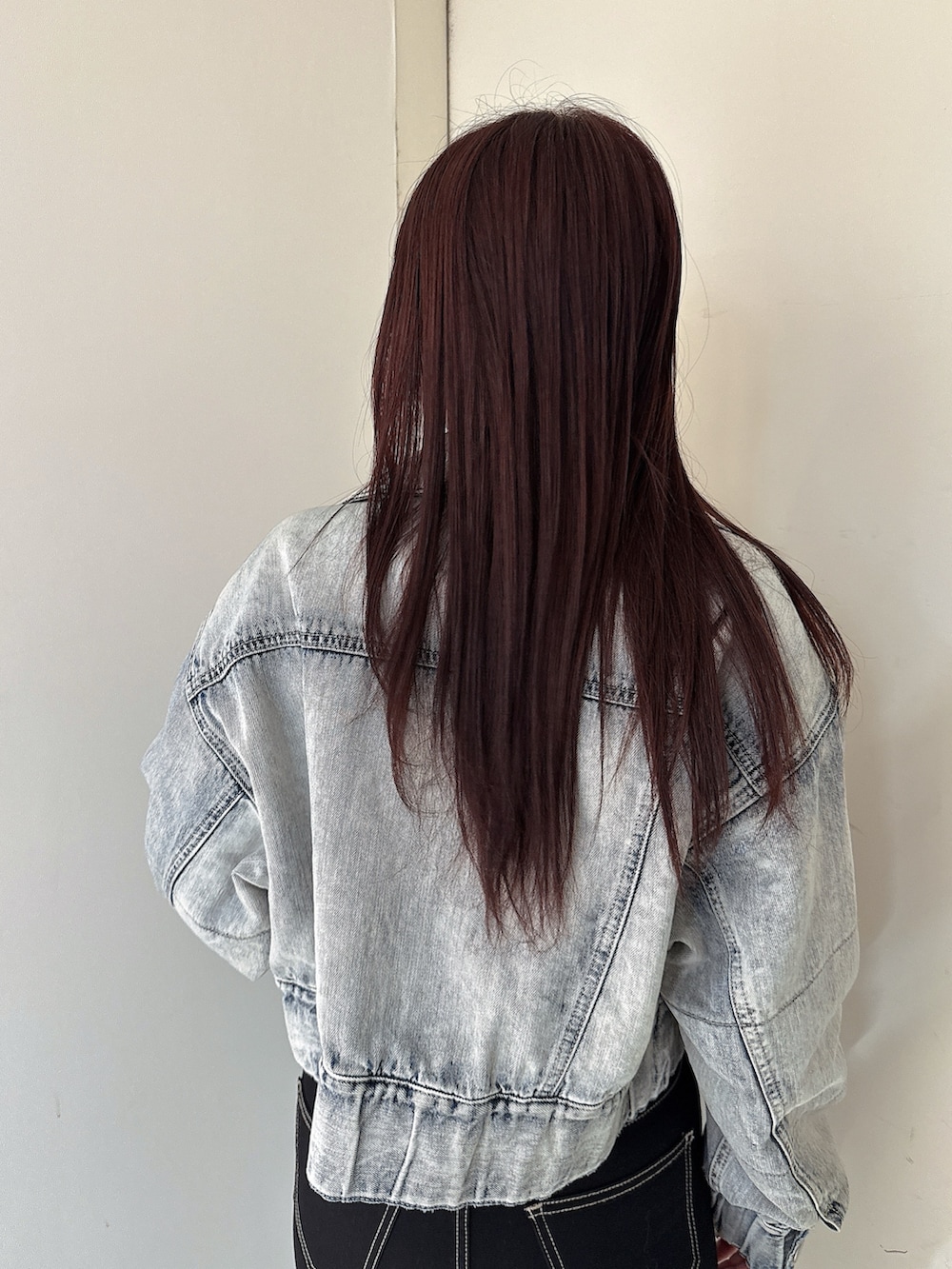 ブラック系のニット/セーター、ブラック系のデニムパンツ、ブラック系のブーツを着用したレディースの秋コーディネートの6枚目の写真