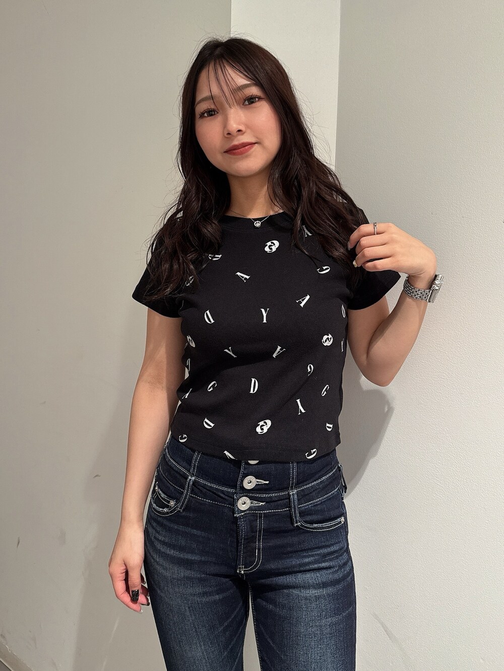 ブラック系のTシャツ/カットソー、ブルー系のデニムパンツ、ブラック系のサンダルを着用したレディースの春コーディネートの4枚目の写真