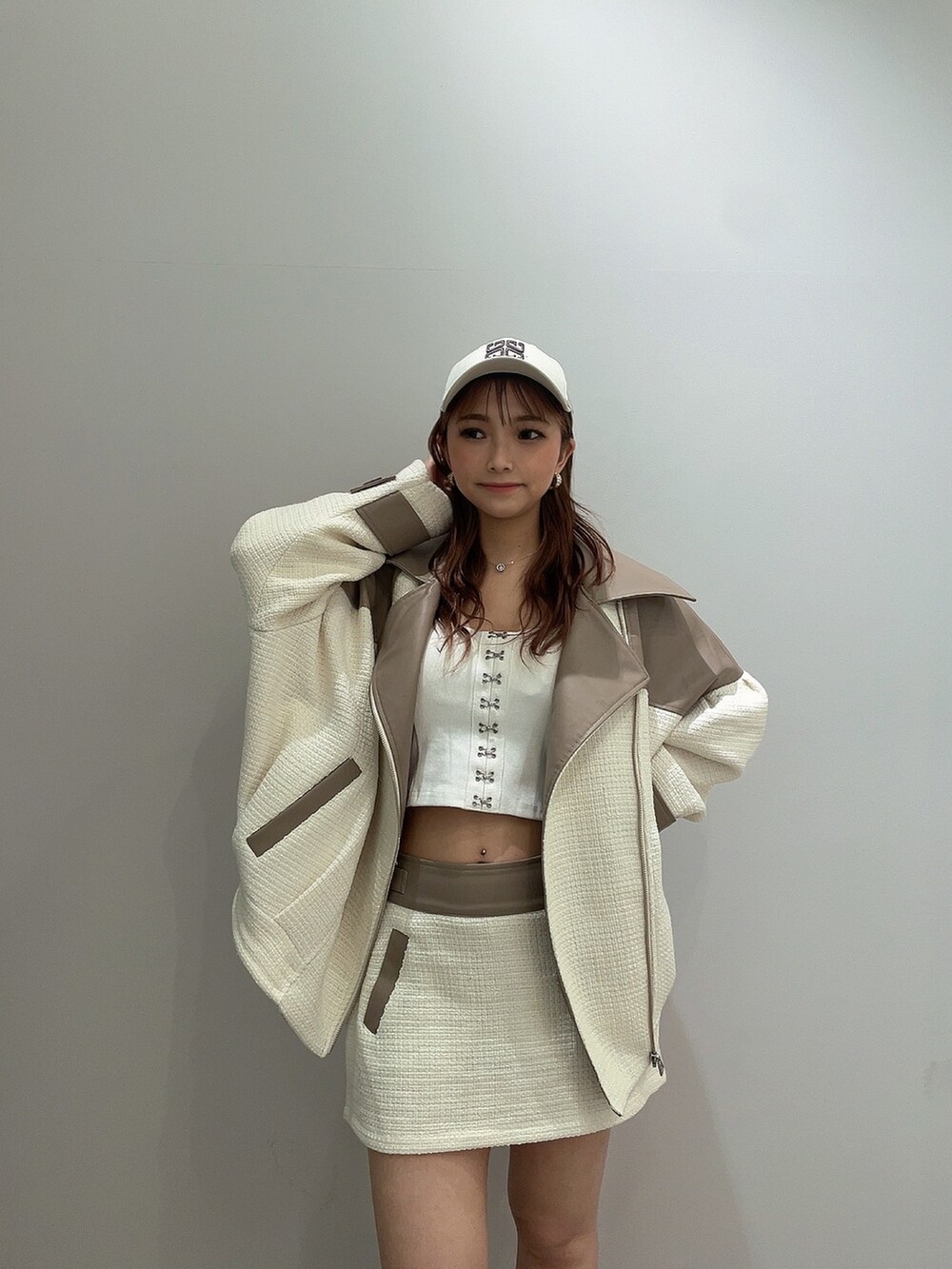 ホワイト系のキャミソール、ホワイト系のライダースジャケット、ホワイト系のスカートを着用したレディースの春コーディネートの3枚目の写真