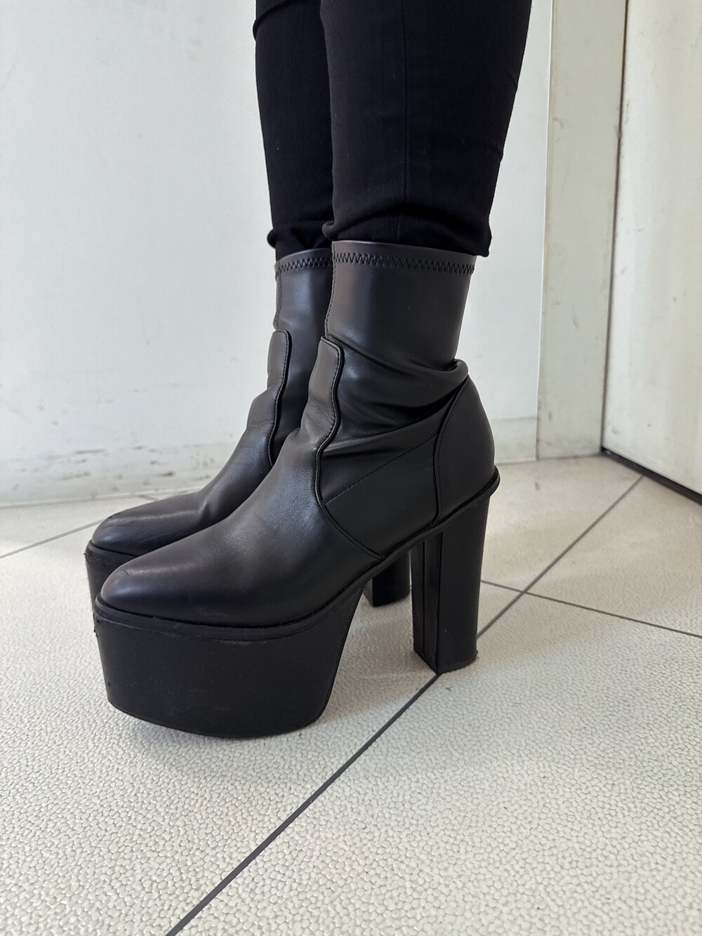 ブラック系のブーツ、ブルー系のデニムパンツ、ブラック系のニット/セーターを着用したレディースの秋コーディネートの9枚目の写真