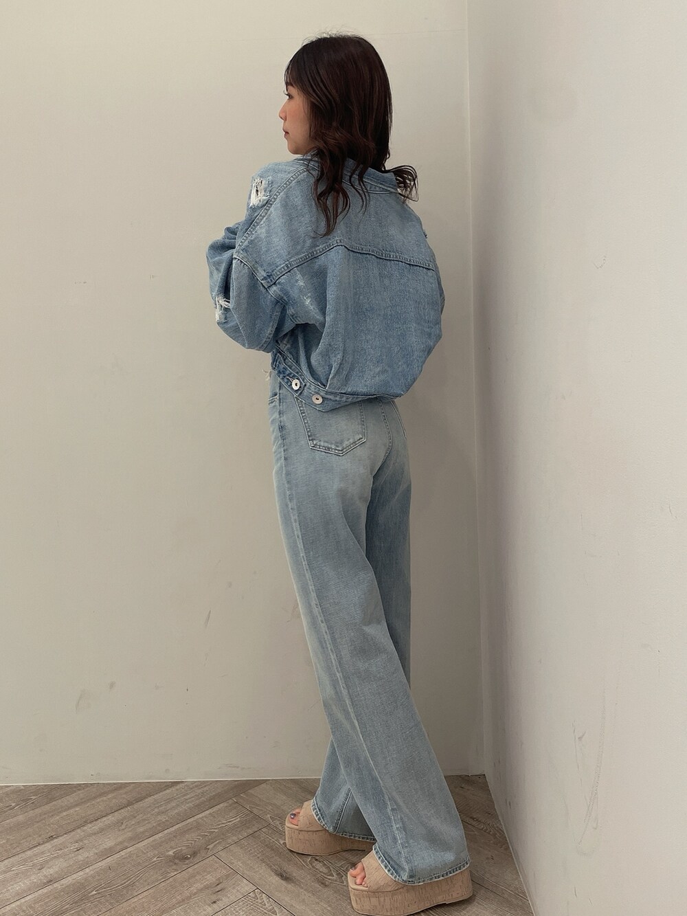 ホワイト系のサンダル、ブルー系のチューブトップ、ブルー系のデニムジャケットを着用したレディースの春コーディネートの2枚目の写真