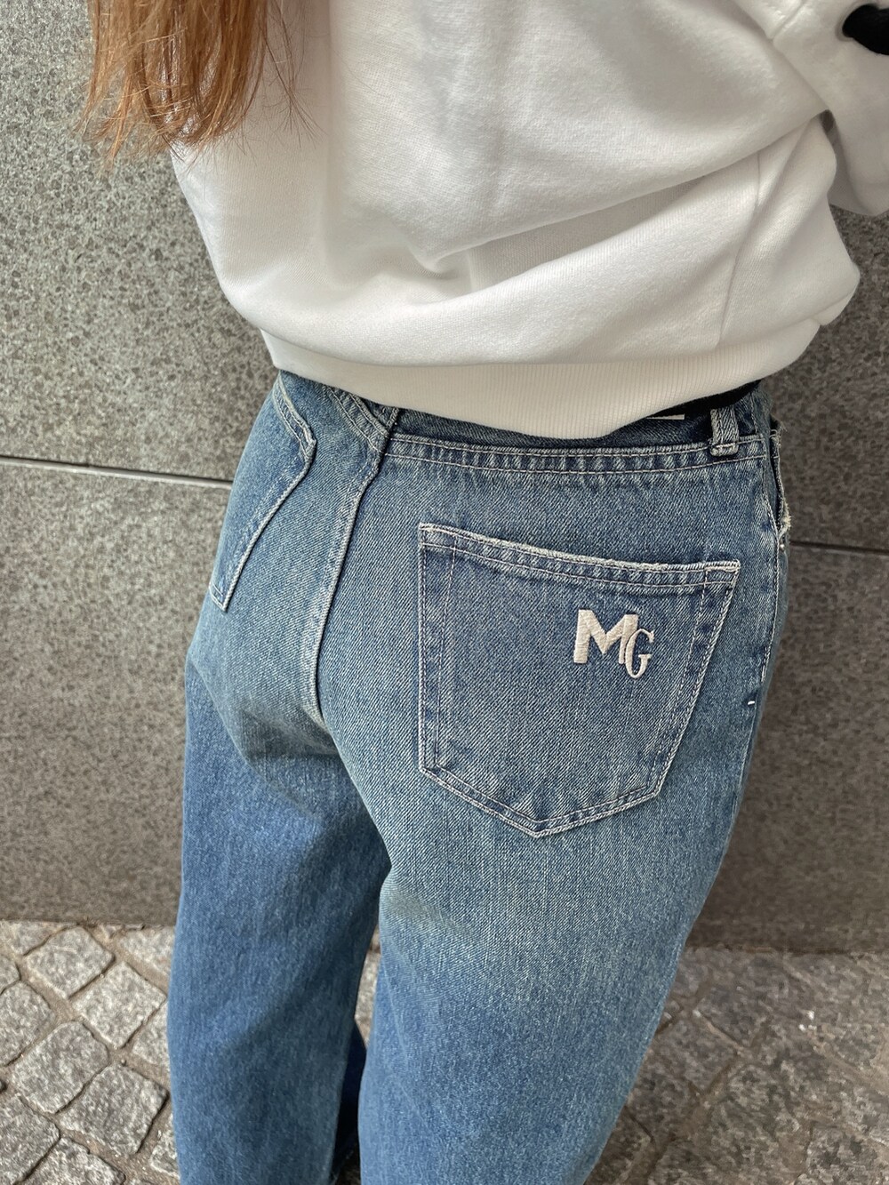 ブラック系のブーツ、ブラック系のデニムパンツ、ホワイト系のスウェットを着用したレディースの秋コーディネートの8枚目の写真