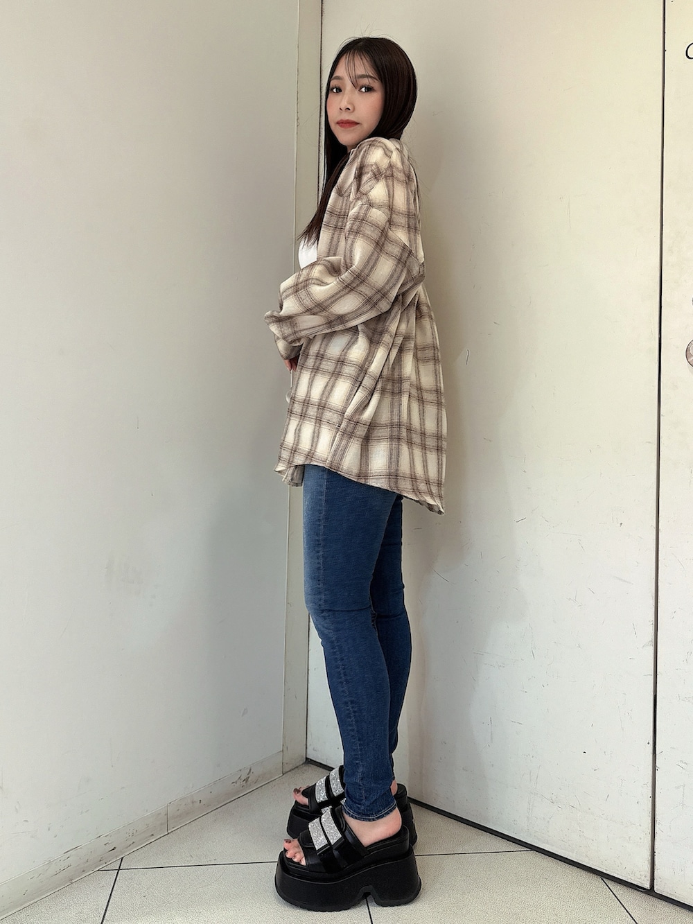 ベージュ系のシャツ/ブラウス、ブルー系のデニムパンツ、ブラック系のサンダルを着用したレディースの春コーディネートの2枚目の写真