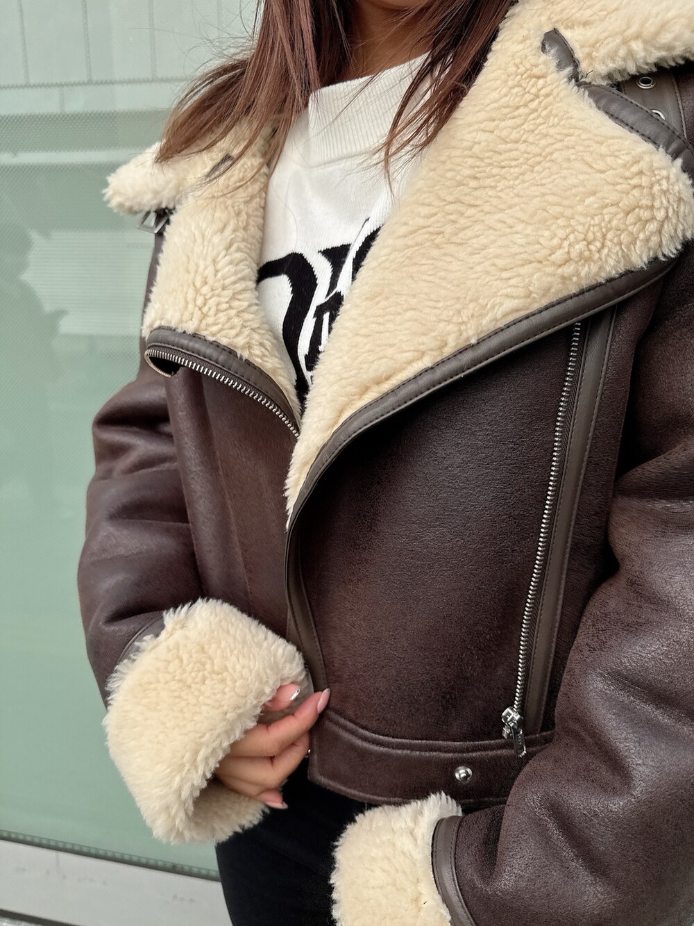 ブラック系のデニムパンツ、ブラック系のブーツ、ホワイト系のニット/セーターを着用したレディースの秋コーディネートの7枚目の写真