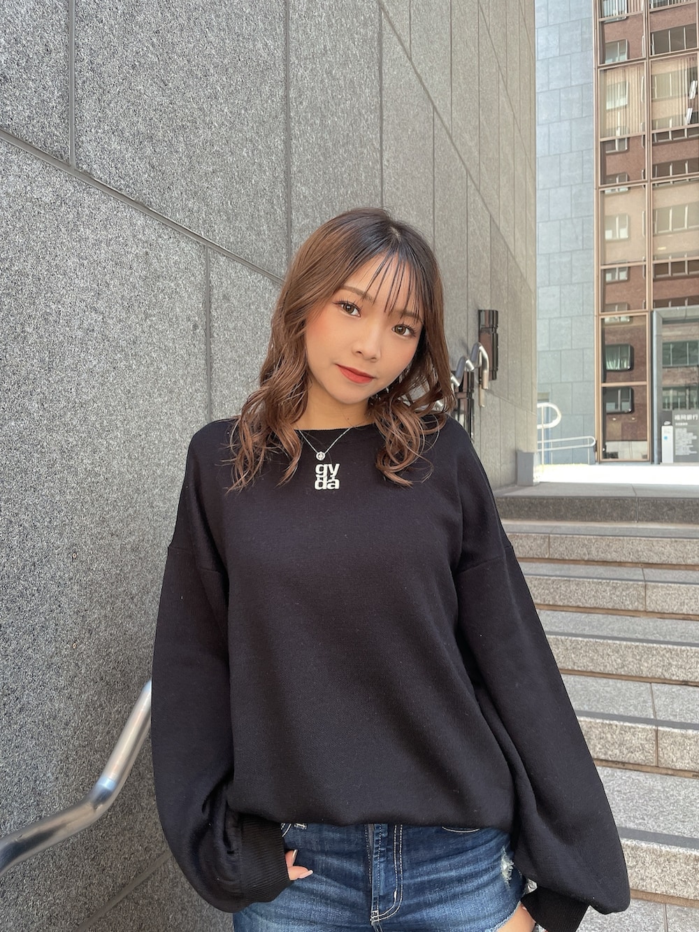 ブラック系のニット/セーター、ブルー系のデニムパンツ、ブラック系のパンプスを着用したレディースの冬コーディネートの3枚目の写真