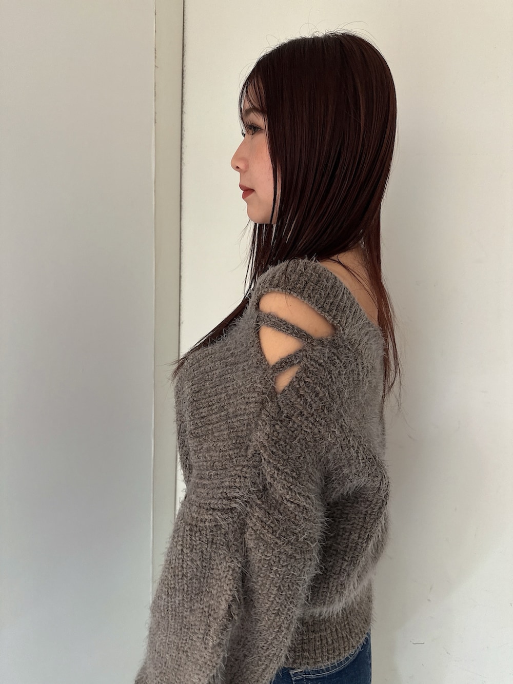 ブルー系のデニムパンツ、ブラック系のブーツ、グレー系のニット/セーターを着用したレディースの秋コーディネートの5枚目の写真