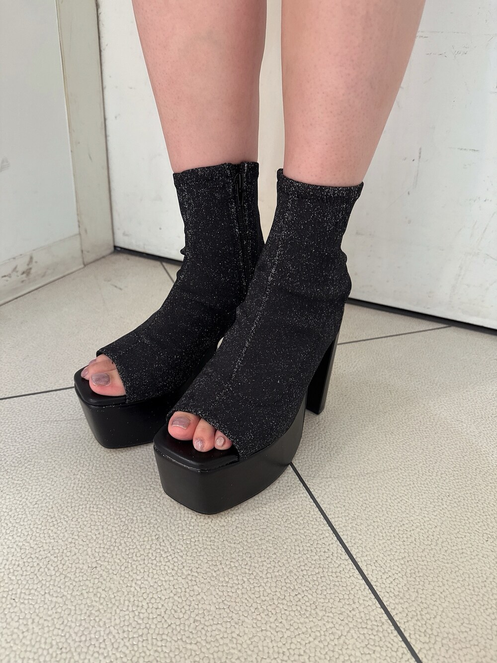 ブラック系のスカート、ホワイト系のタンクトップ、ブラック系のサンダルを着用したレディースの夏コーディネートの10枚目の写真